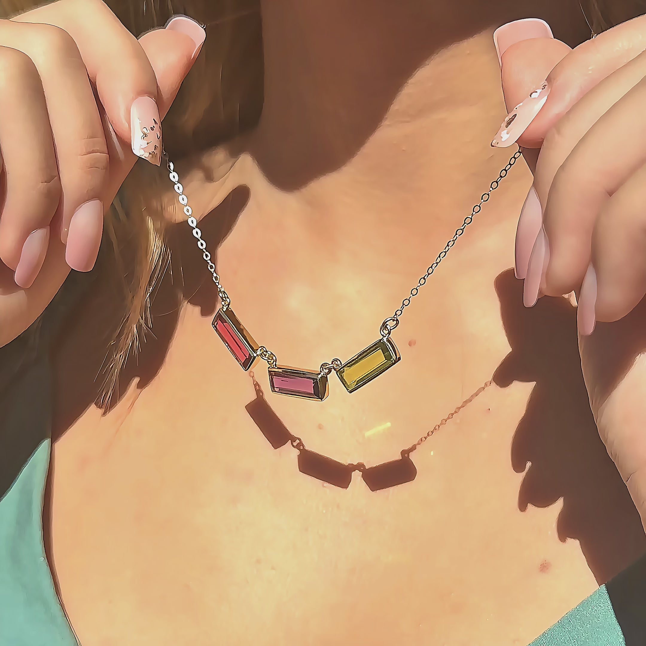 video showcasing custom mom birthstone name necklace with three vertical bar gemstones in gold, featuring blue topaz, ruby and pink quartz bars on a delicate chain, highlighting movement, sparkle and layering style; personalized family jewelry designed to represent children’s birthstones; meaningful Mother’s Day, birthday or Christmas gift idea for moms, grandmas or new moms looking for modern keepsake jewelry