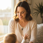 Smiling mom wearing her custom birthstone necklace while cuddling her child, showcasing how the teardrop birthstone pendant sits at the perfect everyday length. Meaningful personalized mom necklace with children’s birthstones, ideal for Mother’s Day, baby shower, push present, or Christmas, a sentimental family keepsake she can wear daily in gold filled or sterling silver.