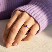 Minimalist amethyst ring worn on hand, delicate purple gemstone stacking ring