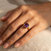 Dainty gold amethyst ring on finger, faceted purple February birthstone ring, everyday minimalist gemstone jewelry for women