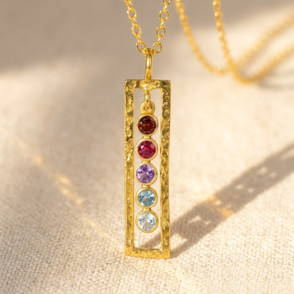 Personalized vertical birthstone bar necklace with five colorful stones on a gold rectangular pendant, custom family jewelry for mom or grandma.