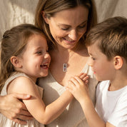 Mother wearing a custom vertical birthstone necklace while smiling with her children, thoughtful family keepsake jewelry.