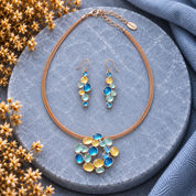 Colorful boho bubble cluster necklace and cascading earrings with blue aqua and gold accents on dark stone

