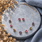 Berry Plum Color Bloom necklace and matching stud earrings displayed on gray stone
