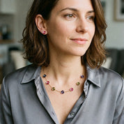 Woman wearing colorful Color Bloom station necklace with plum top outdoors