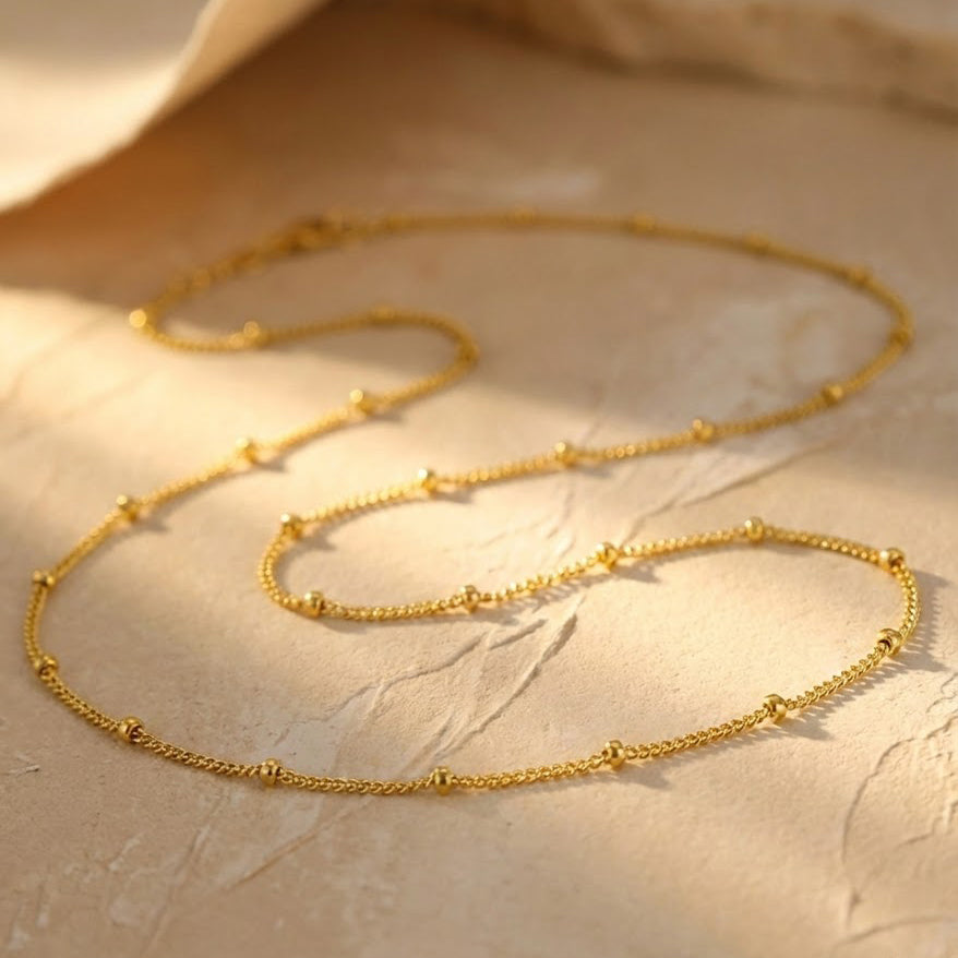 Minimalist satellite chain choker laid flat displaying four finishes including bright sterling silver, oxidized silver, 14K yellow gold filled, and 14K rose gold filled, highlighting the delicate dew drop bead details and elegant craftsmanship of this handmade necklace