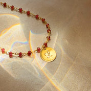Personalized gold initial disc pendant on red gemstone wire-wrapped chain featuring hand-engraved letter charm. Bold, colorful beaded design ideal for meaningful custom jewelry gifts for mom, daughter, girlfriend, sister, or friend. Perfect for holidays, birthdays, Mother’s Day, or everyday wear with adjustable length and multiple engraving options.