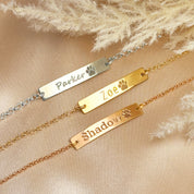 Sterling silver, gold filled, and rose gold paw print bar bracelets engraved with pet names “Parker,” “Zoe,” and “Shadow.” Personalized pet lover jewelry with engraved paw symbol and adjustable chain. Perfect gift for dog moms, cat owners, and animal lovers. Available in multiple metal finishes, optional back engraving, and packaged in Danique Jewelry gift box.