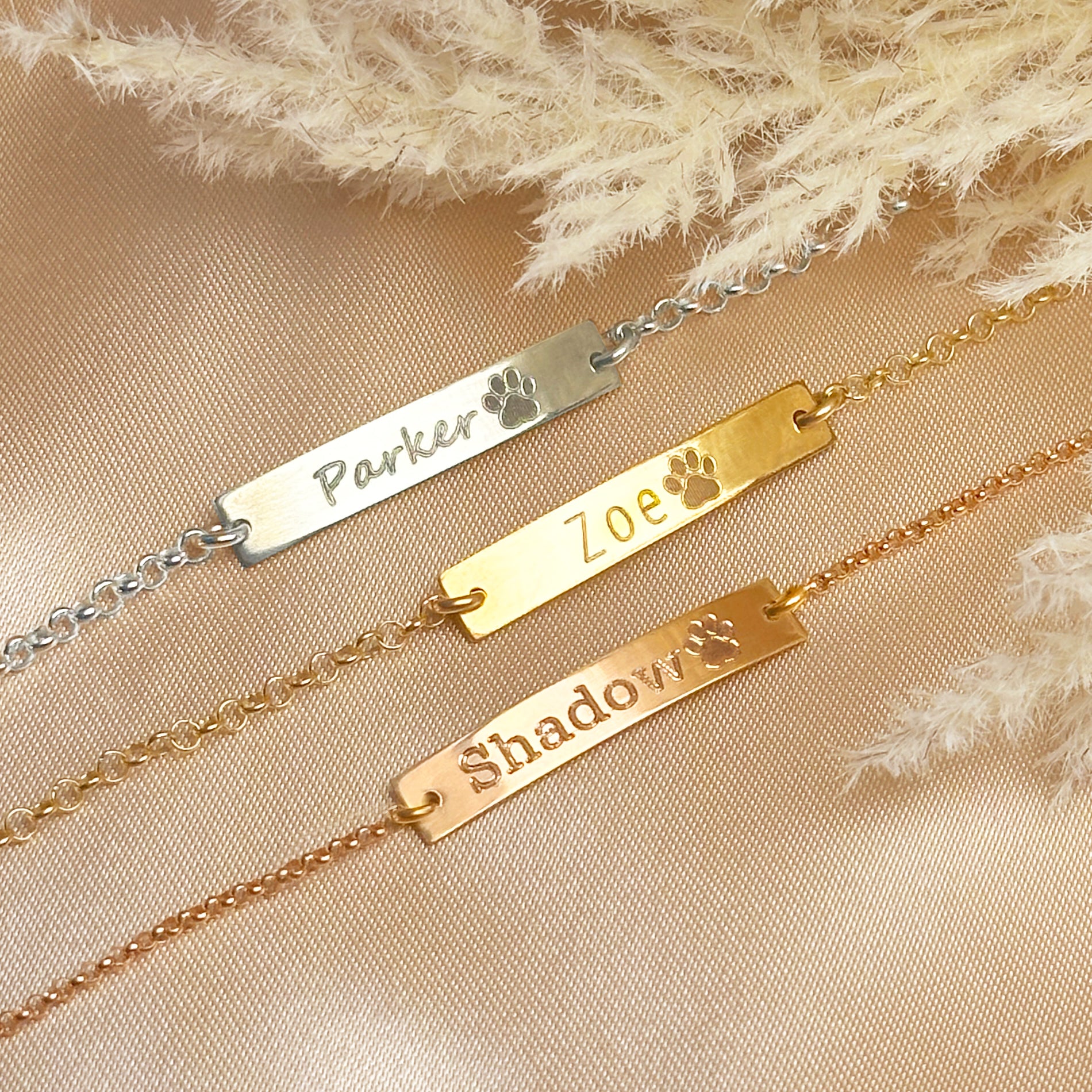 Sterling silver, gold filled, and rose gold paw print bar bracelets engraved with pet names “Parker,” “Zoe,” and “Shadow.” Personalized pet lover jewelry with engraved paw symbol and adjustable chain. Perfect gift for dog moms, cat owners, and animal lovers. Available in multiple metal finishes, optional back engraving, and packaged in Danique Jewelry gift box.