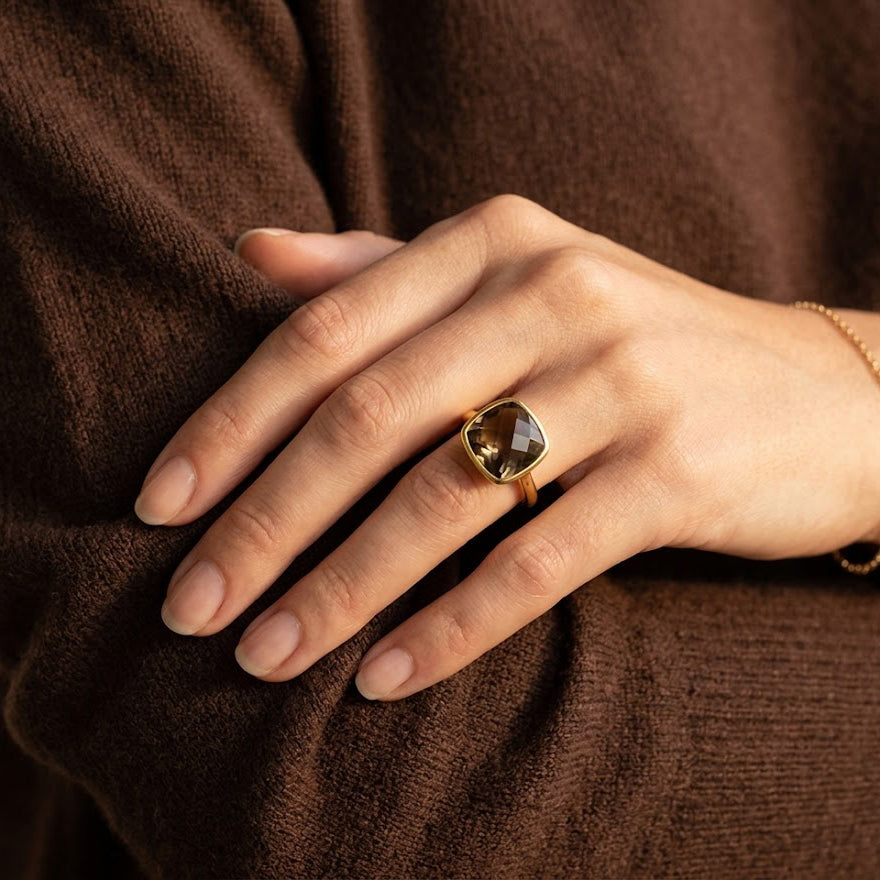 Smoky quartz cushion ring worn on hand with warm brown gemstone glow