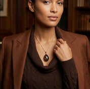 Woman wearing custom teardrop birthstone necklace with black gemstone pendant
