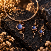 Boho serpentine necklace and matching abstract earrings displayed on dark textured stone

