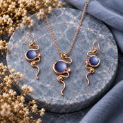 Boho serpentine necklace and matching earrings in blue and blush colors on gray stone

