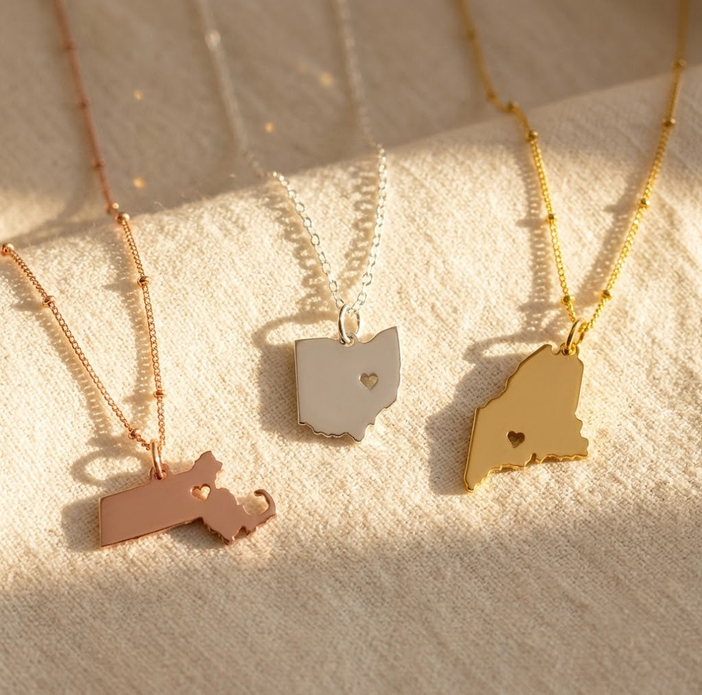 Custom state and county necklaces in silver, gold and rose gold with personalized heart cutout