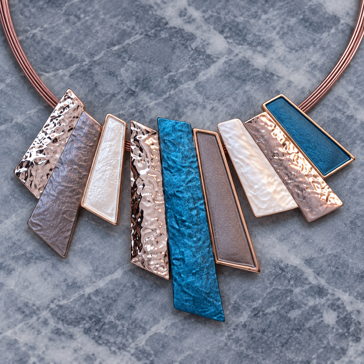Close up of Modernist Fan necklace with layered teal blue pearl gray and metallic geometric panels

