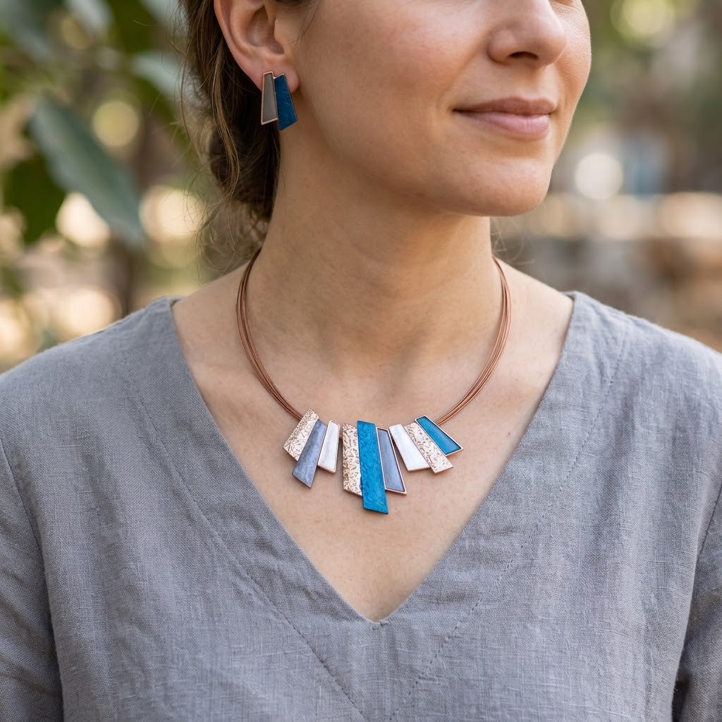 Woman wearing Ocean Breeze geometric Fan statement necklace and matching stud earrings

