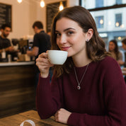 Woman wearing a matching sun pendant necklace and sunburst stud earrings set with a sparkling birthstone center, minimalist celestial jewelry set styled in a cozy café, personalized birthstone necklace and earrings for women, meaningful gift for girlfriend, wife, or daughter, perfect for Valentine’s Day, birthday, or everyday wear