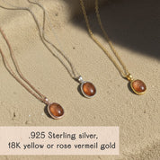 Dainty oval sunstone necklaces in .925 sterling silver, 18k yellow gold vermeil and 18k rose gold vermeil displayed on a warm sand textured background, each pendant featuring a glowing coppery orange sunstone cabochon with subtle sparkle on a fine minimalist chain. Elegant boho gemstone necklace perfect for everyday wear or layering, a meaningful gift for her, mom, sister or best friend for birthdays, anniversaries, Christmas or Mother’s Day.