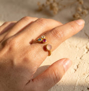 Personalized mom and three kids birthstone ring worn on hand with four custom family gemstones