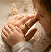 Woman wearing custom mom of three birthstone ring with personalized family gemstones on her hand