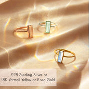 Custom birthstone baguette ring trio displayed on soft champagne satin, featuring slender vertical gemstone bars set in minimalist bands of .925 sterling silver, 18K vermeil yellow gold and rose gold. Modern stacking ring design that can be personalized with your choice of birthstone, perfect as a dainty everyday piece or meaningful gift for birthday, anniversary, bridesmaids or Mother’s Day.
