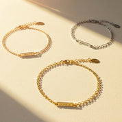 personalized tiny bar bracelets shown in sterling silver and gold vermeil, each featuring a slim engravable bar with custom names, monograms or dates, displayed on soft neutral linen fabric for a minimalist, elegant presentation, offering adjustable or fixed chain lengths and multiple engraving fonts, perfect as custom bridesmaid jewelry, birthday gifts or everyday stacking bracelets for women who love dainty personalized accessories