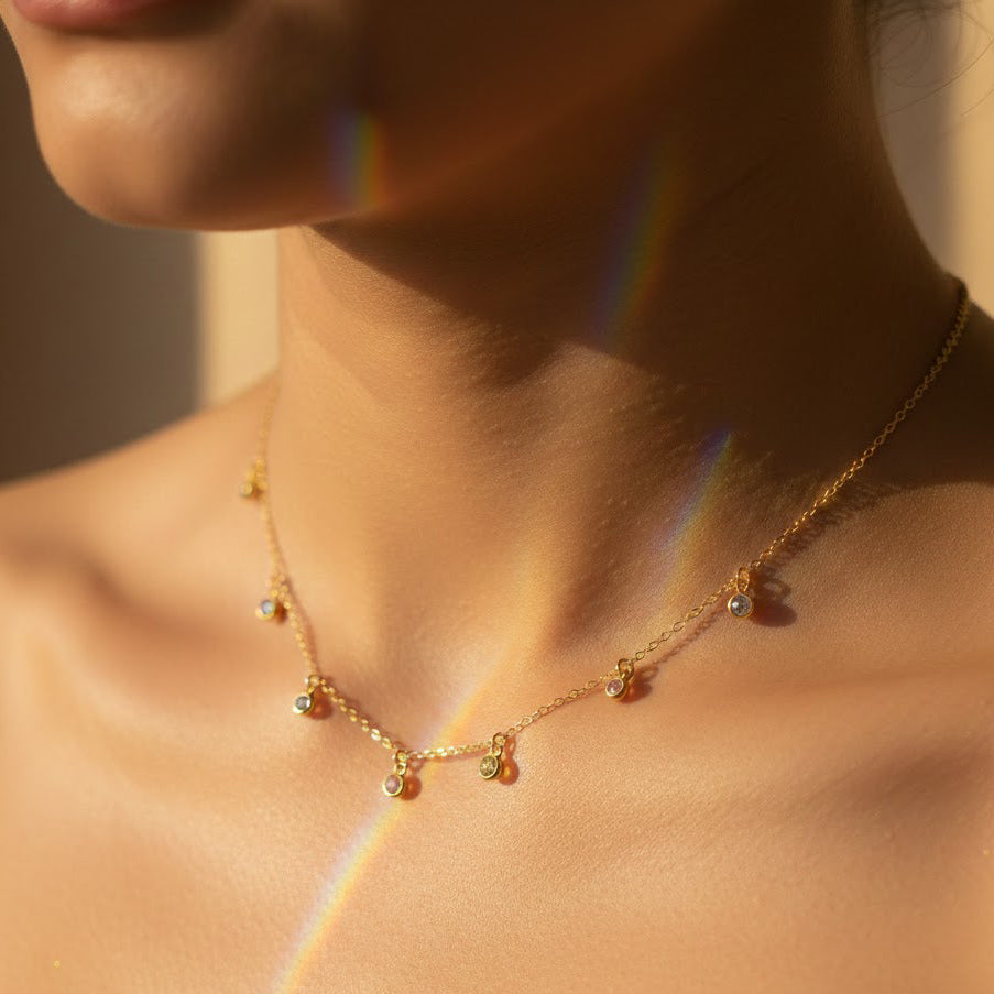 Close-up of custom birthstone necklace with multiple tiny bezel gemstones in sterling silver and gold — personalized family keepsake necklace gift for mom and grandma