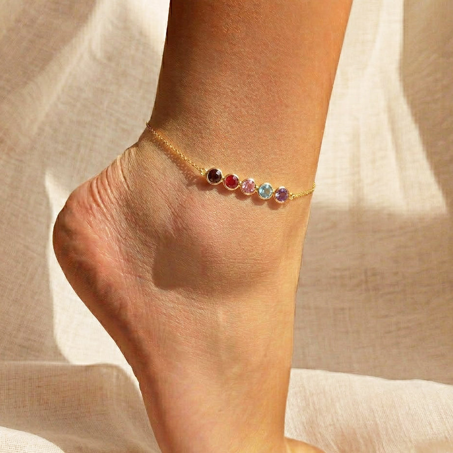 Personalized birthstone bar anklet in gold, shown worn on the ankle, featuring sparkling gemstones that symbolize family members or special milestones. This dainty anklet is adjustable for comfort and available in sterling silver, gold, or rose gold. A minimalist and meaningful jewelry gift for moms, daughters, or best friends, this anklet makes a thoughtful birthday present, Mother’s Day keepsake, or summer accessory.