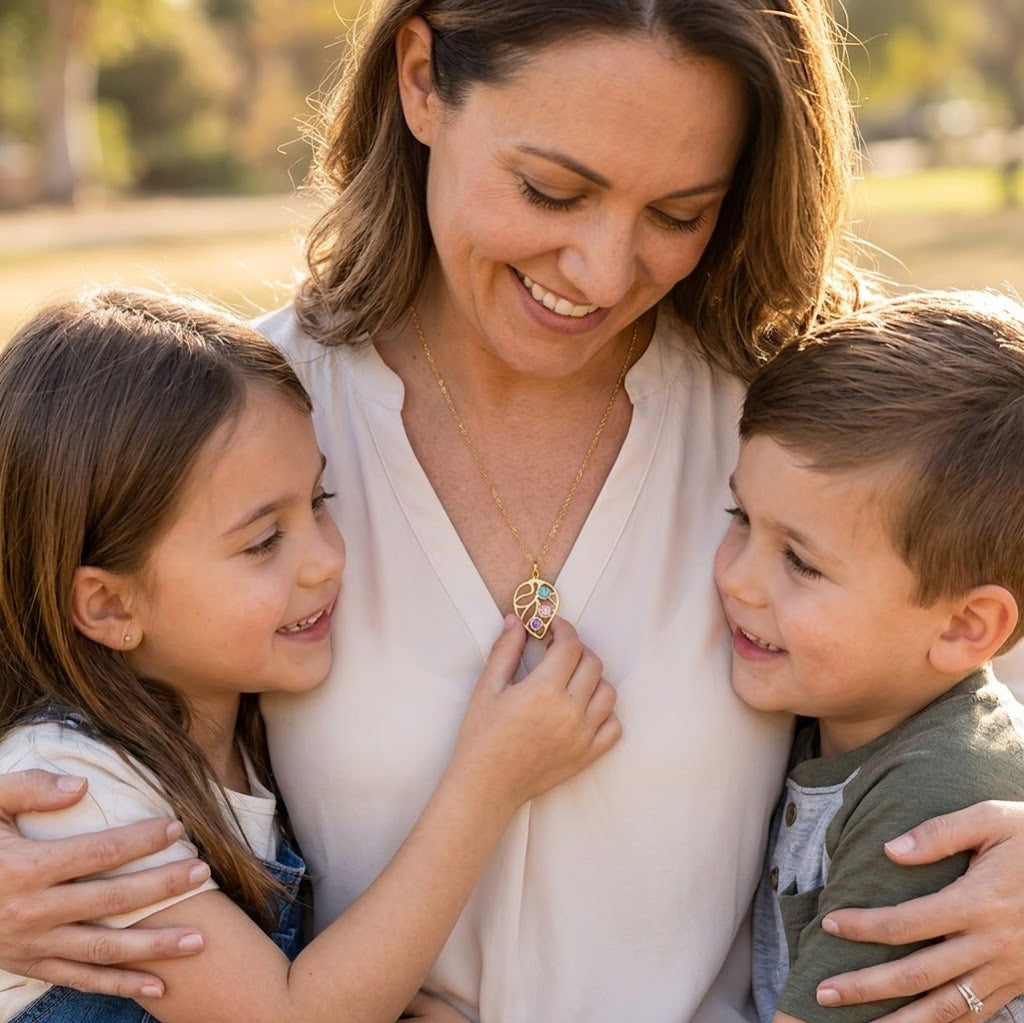 Mother wearing a custom leaf birthstone necklace while smiling with her children, sentimental family jewelry gift for mom.