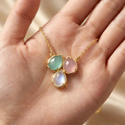 Close-up of three custom teardrop birthstone charms in hand, personalized necklace for mom, grandma, sisters, or best friends.