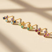 Custom birthstone stud earrings arranged on neutral fabric, perfect for choosing three children’s birthstones or family stones.