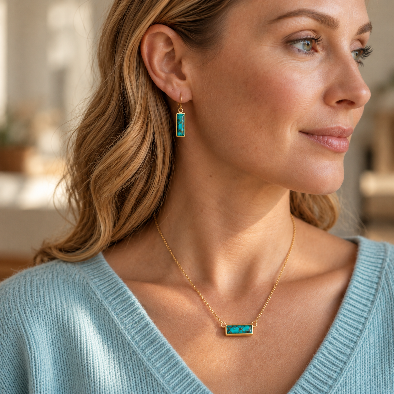 Woman wearing a personalized turquoise bar necklace with engraved rectangular gemstone pendant on a delicate gold chain.
