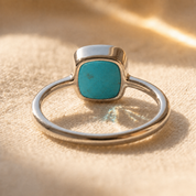 Sterling silver turquoise cushion ring shown from the side with slim band.