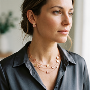 Woman wearing Blush Pink and Rose Gold double disc stud earrings with layered necklace
