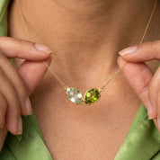 Custom two birthstone necklace with two faceted teardrop gemstones in yellow gold representing loved ones.