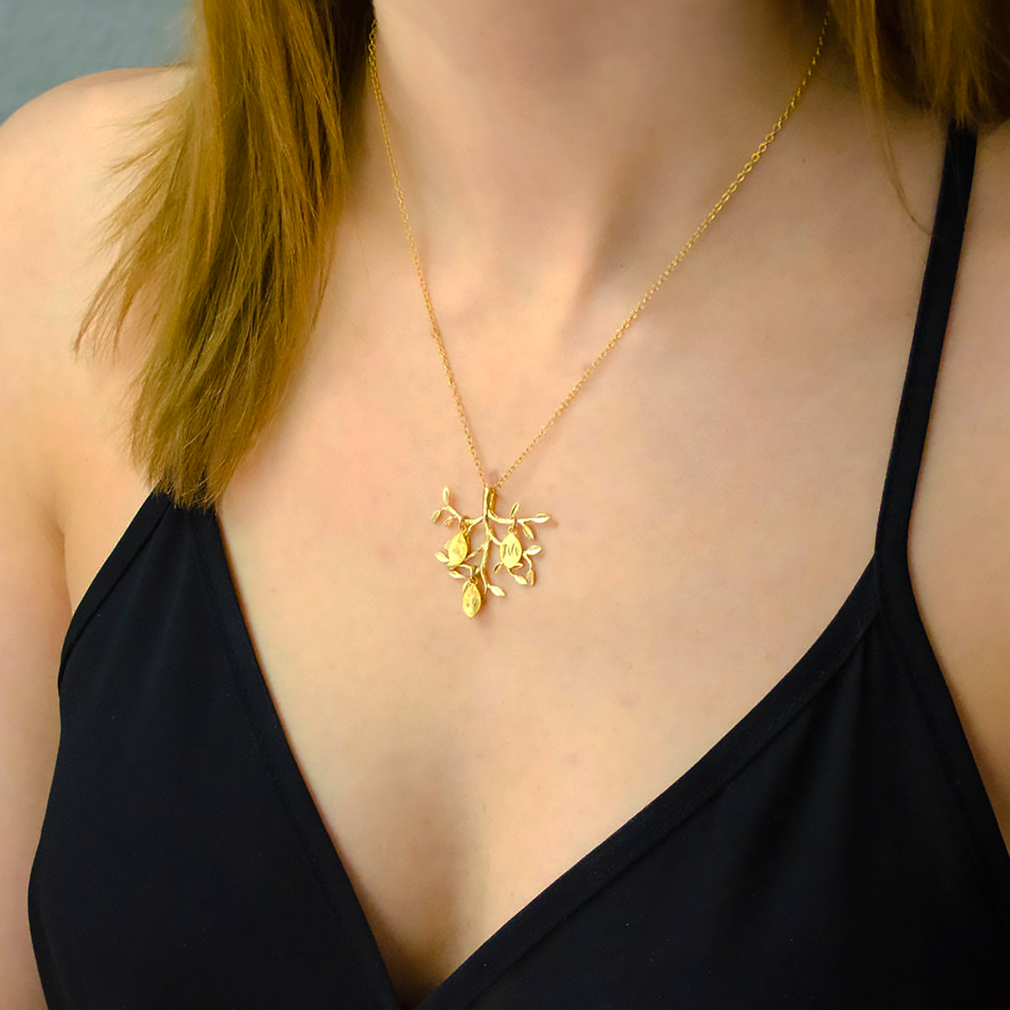 upside_down_tree_pendant_with_leaf_initials_on_person.png