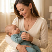 New mom wearing a delicate custom birthstone necklace while holding her baby, perfect for celebrating motherhood and family.