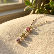 Gold family birthstone necklace for mom with multiple small gemstone charms, designed as a meaningful Mother’s Day keepsake.