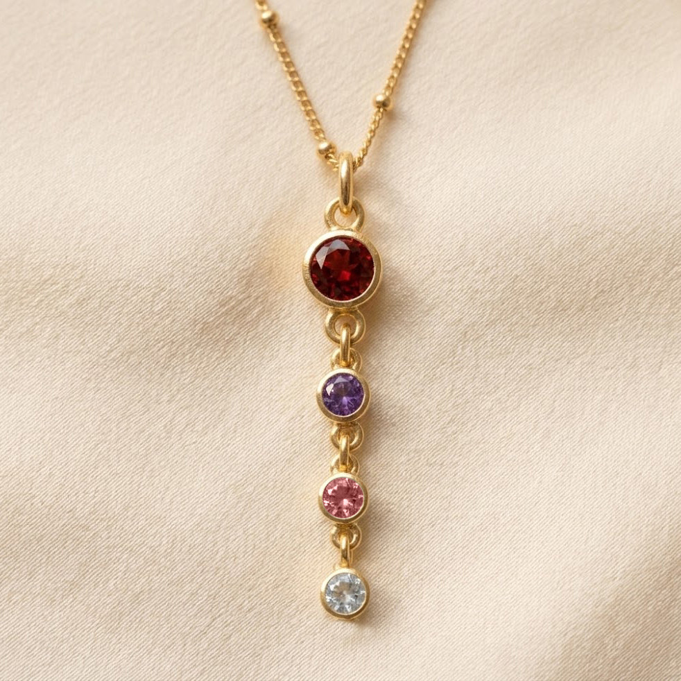 Custom birthstone mom necklace with vertical round gemstone charms representing children or loved ones on a delicate gold chain.