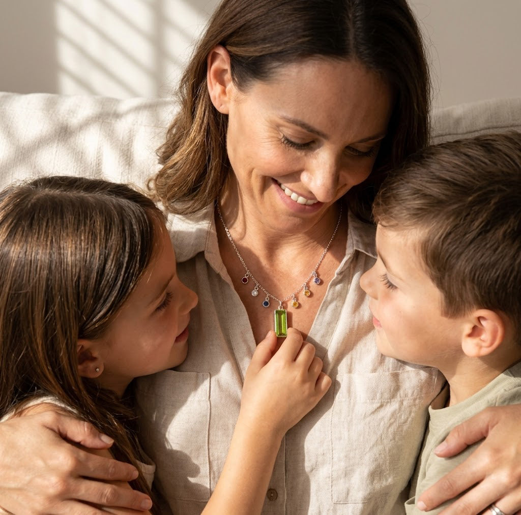 Mother wearing a custom birthstone necklace with children beside her, showing a sentimental family jewelry gift designed to celebrate kids, grandkids, and loved ones.