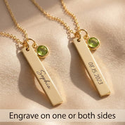 Front and back engraving examples on gold vertical bar necklaces with green checker-faceted birthstone charms.