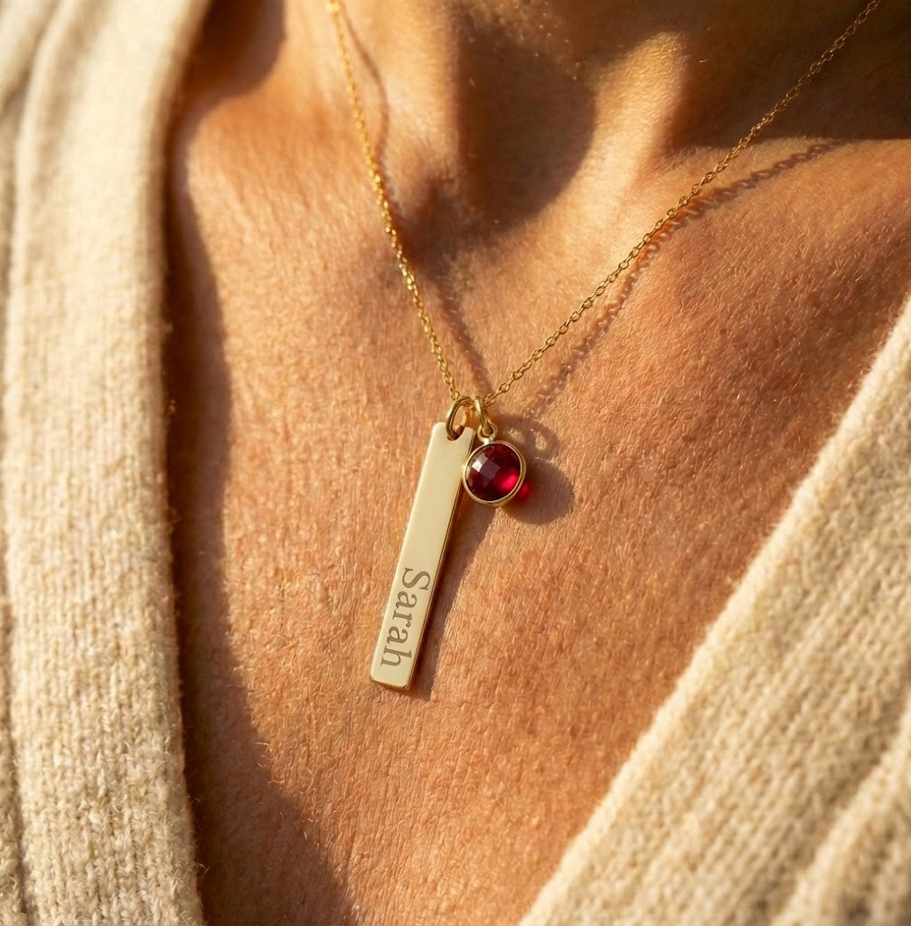 Personalized bar necklace close-up showing engraved name and tiny birthstone charm, minimalist jewelry gift for mom