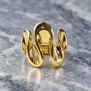 Gold Shifting Waves adjustable sculptural ring displayed on gray stone
