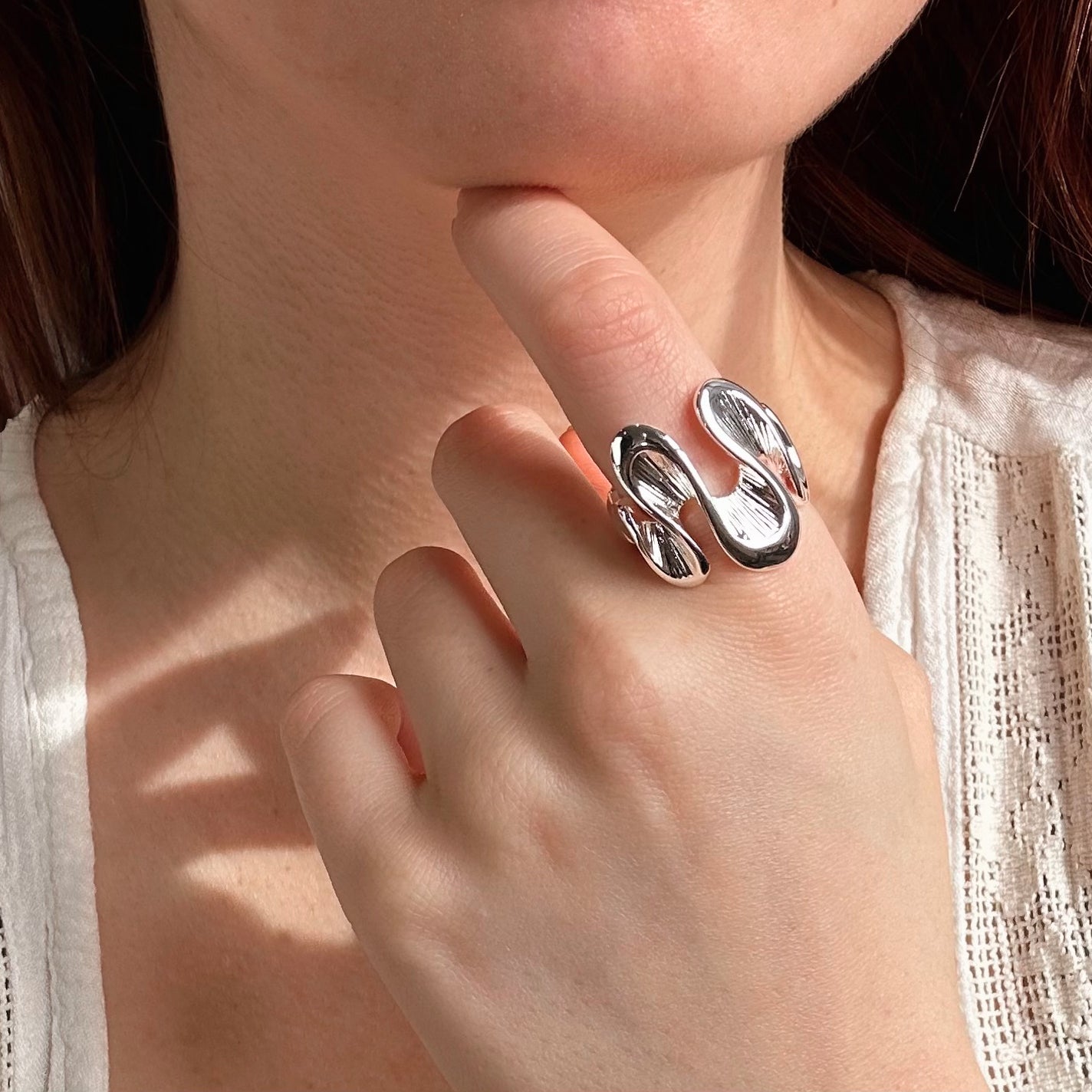 Model wears silver textured wave shaped ring on index finger. Stretchy ring, adjustable to fit ring, wave ring, nature inspired jewelry, boho jewelry, nature inspired ring, ocean ring, water ring, bohemian jewelry, zinc alloy, gold, silver, one size fits most, ring for her, mother's day git, christmas gift, gift for girlfriend