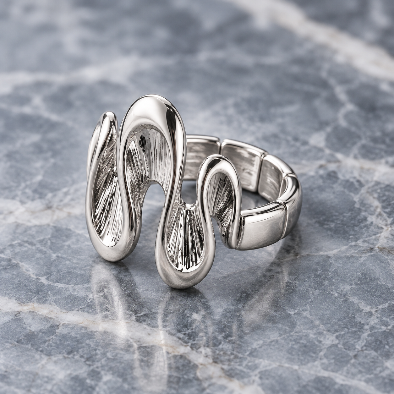 Silver Shifting Waves adjustable ring shown from angled side view on gray stone

