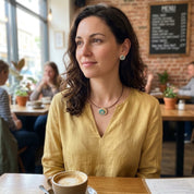 
Woman wearing turquoise gold boho spiral pendant necklace in cafe setting

