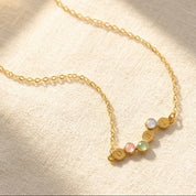 Personalized birthstone and initial necklace with four petite family gemstones in yellow gold
