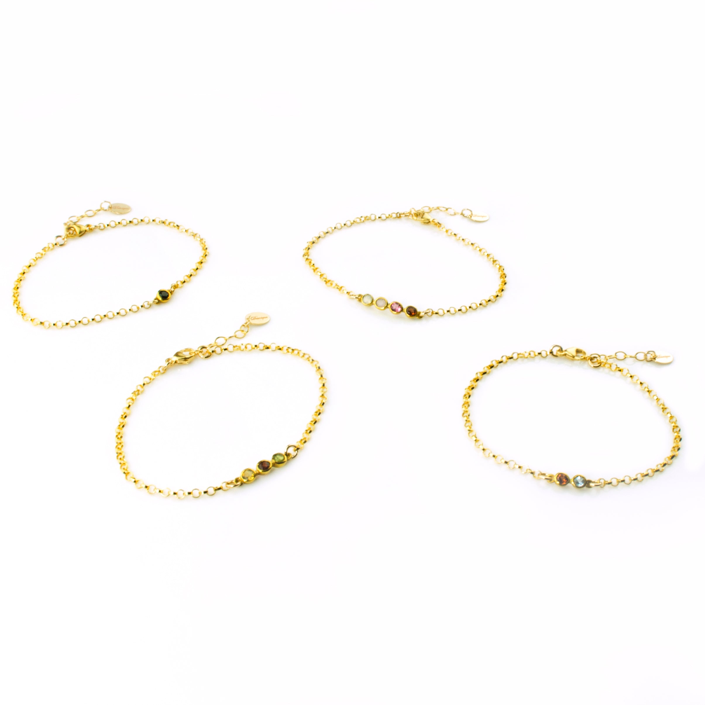 four gold anklet options featuring black onyx, peridot, pink chalcedony, garnet, iolite, ruby quartz and aqua chalcedony. 