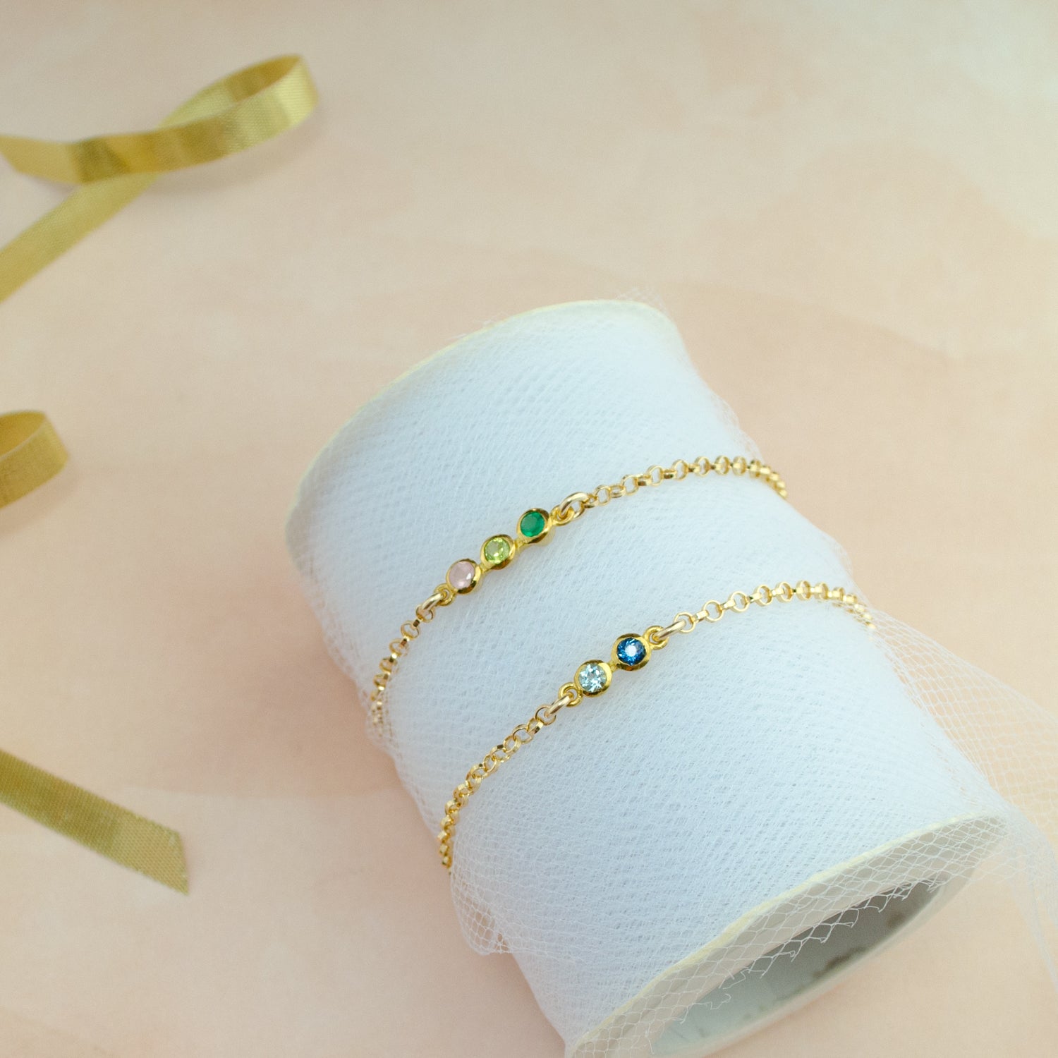 Two gold anklets with blue topaz and  iolite, one anklet with green onyx, peridot and pink chalcedony. 