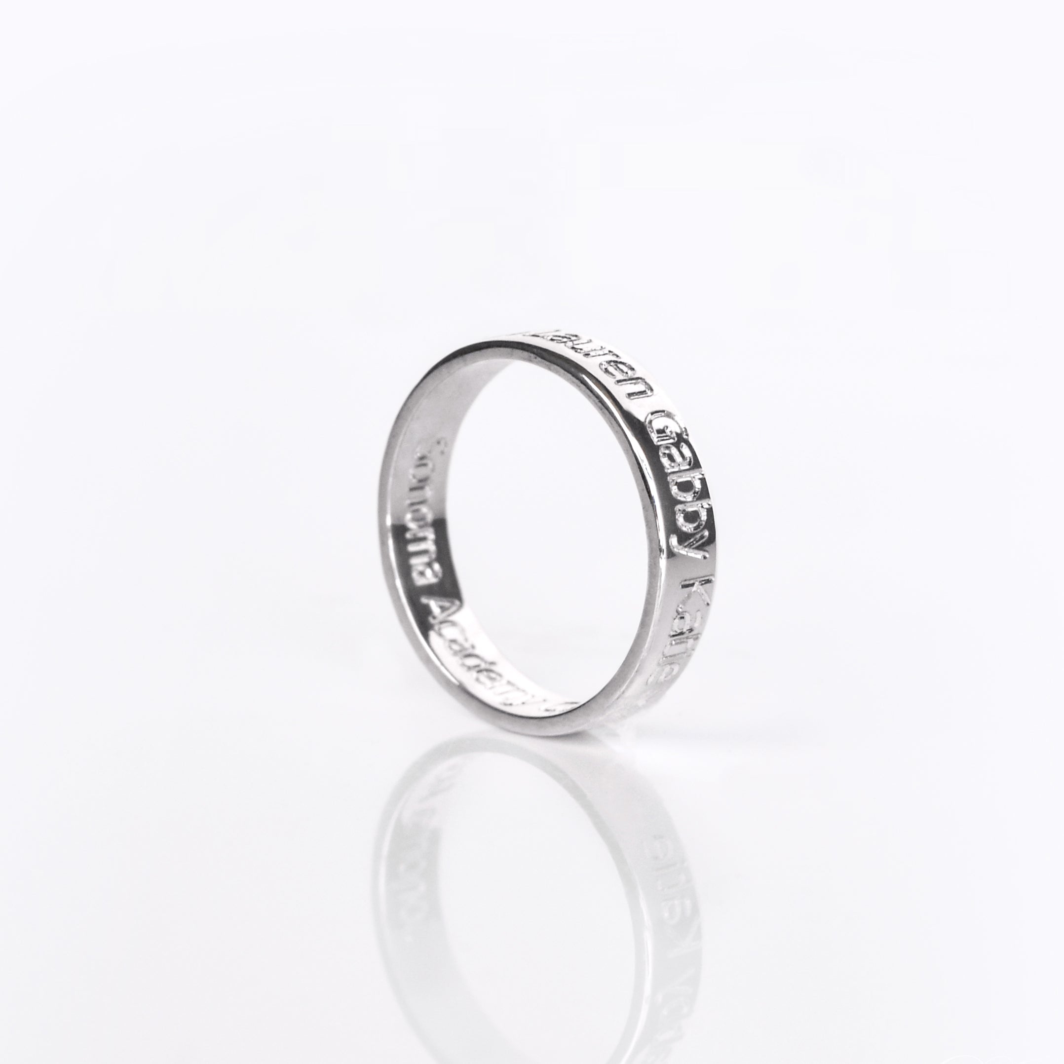 A sterling silver engraved ring on its side. Names are visibly engraved on the sides. Fingerprint engraved ring, custom handwriting band, 4mm sterling silver, gold personalized jewelry, rose gold thin band, special name engraving, date and location, photo engraving, thoughtful gift, meaningful keepsake, inside or outside engraving, US sizes 4-13
